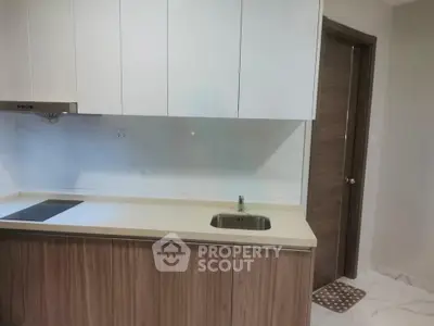 Modern kitchen with sleek cabinetry and induction cooktop in a stylish apartment.