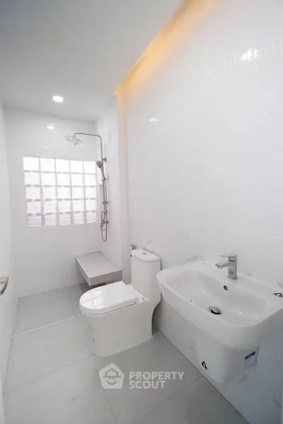 Modern minimalist bathroom with sleek fixtures and white tiles