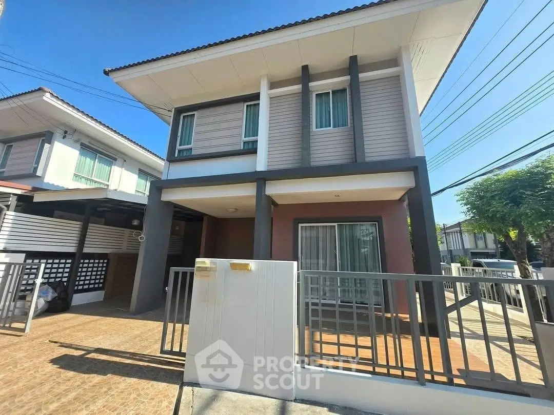 Modern two-story house with sleek design and spacious driveway in a sunny neighborhood.
