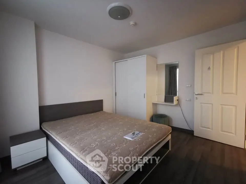 Spacious bedroom with modern furnishings and ample storage in a stylish apartment.