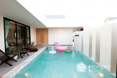 Luxurious private pool with modern design and playful flamingo float in serene villa setting.