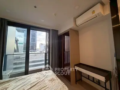Modern bedroom with balcony view in urban apartment, featuring air conditioning and sleek furniture.