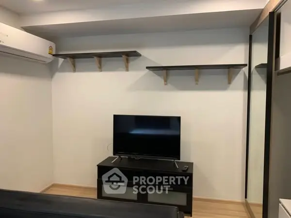 Modern living room with wall-mounted shelves and sleek TV setup