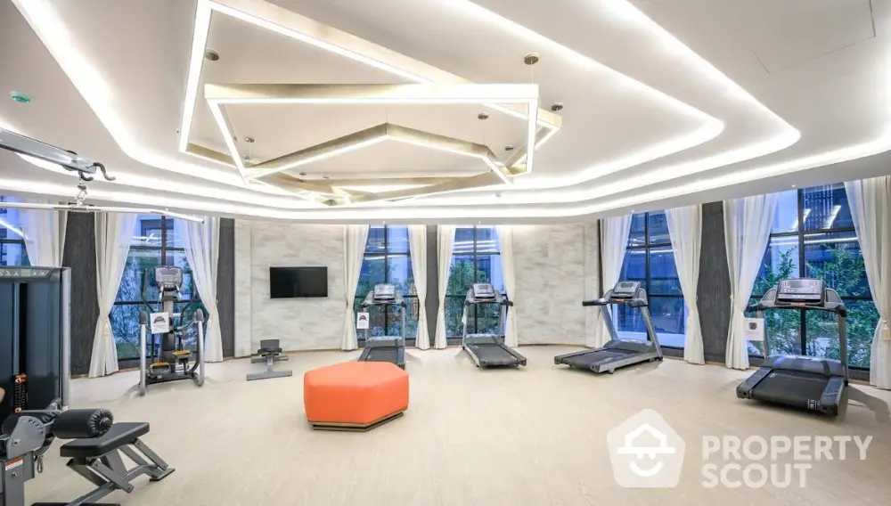 Modern gym with state-of-the-art equipment and stylish lighting in luxury residential building.