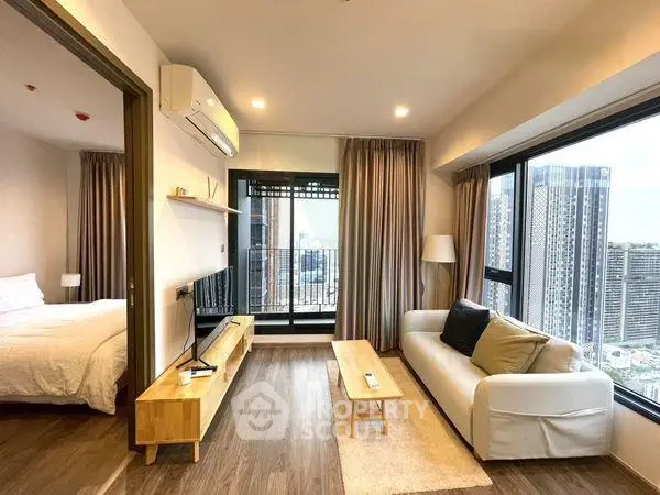 Modern living room with city view, cozy sofa, and adjacent bedroom in a high-rise apartment.