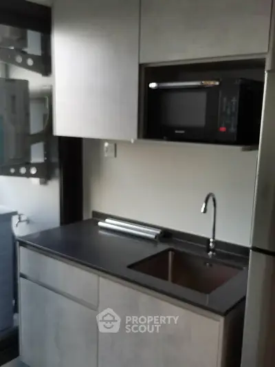 Modern compact kitchen with microwave and sleek cabinetry