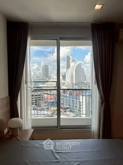 Stunning city view from a modern bedroom with large window and elegant curtains.