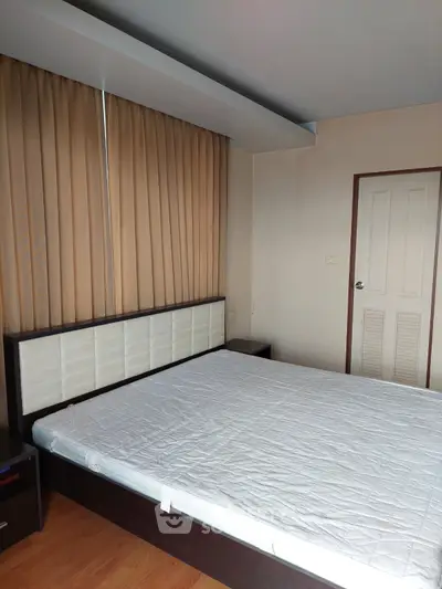 Spacious bedroom with modern decor and large window for natural light