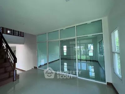 Spacious modern interior with glass partition and staircase, ideal for open living concepts.