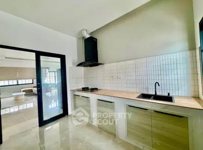 Modern kitchen with sleek design and open layout, featuring gas stove and ample natural light.