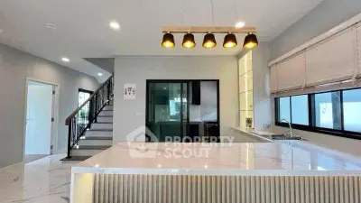 Modern kitchen with marble island and stylish lighting in open layout home