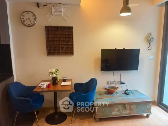 Cozy living room with blue chairs, wall-mounted TV, and stylish decor.