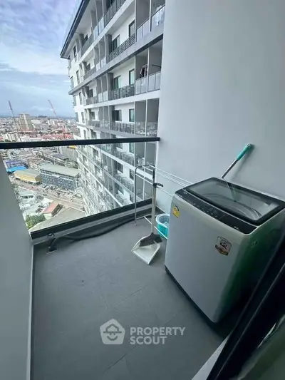 Modern high-rise balcony with city view and washing machine, perfect for urban living.