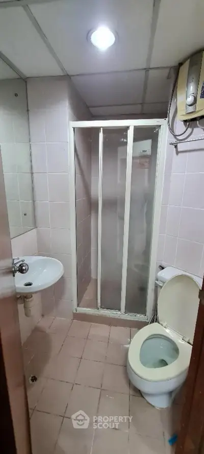 Compact bathroom with shower enclosure and basic fixtures, ideal for small apartments.