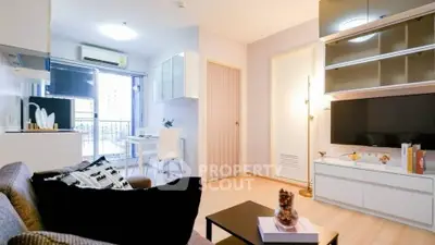 Modern living room with stylish decor and natural light, featuring a cozy sofa and wall-mounted TV.