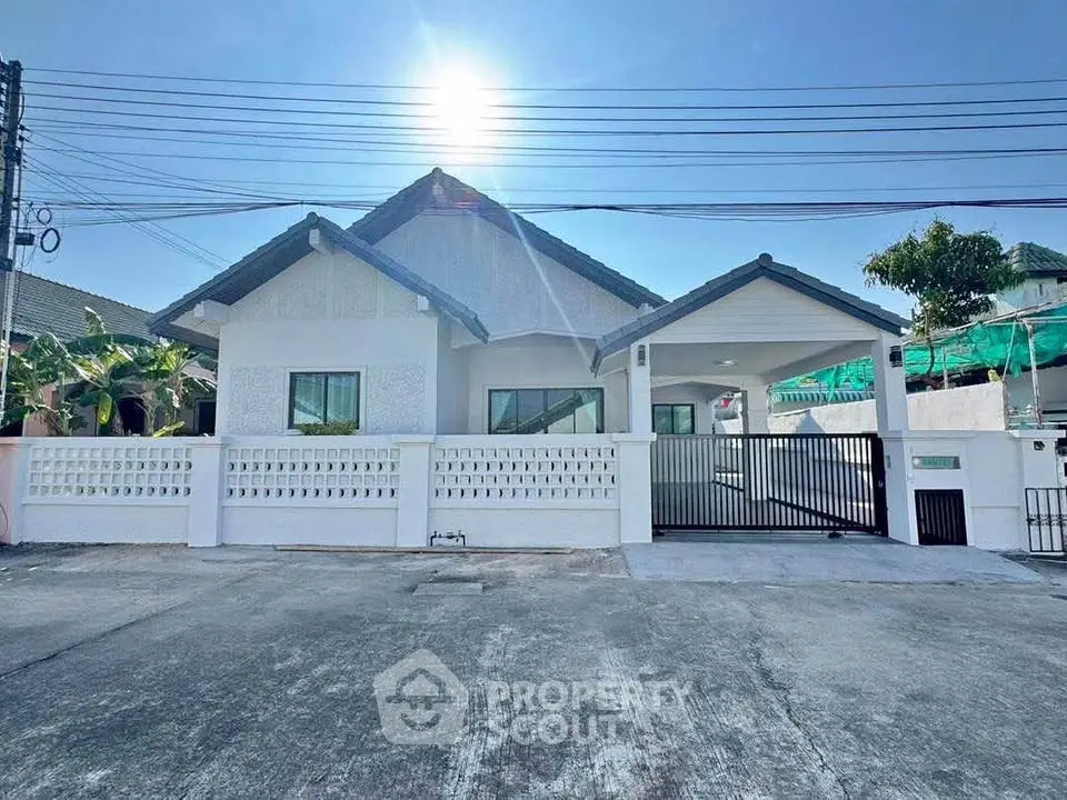 Charming single-story house with modern design and spacious driveway under clear blue sky.
