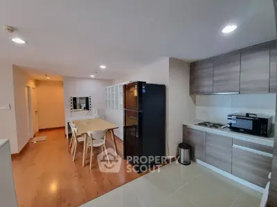 Modern kitchen with sleek cabinetry and dining area in open layout apartment.