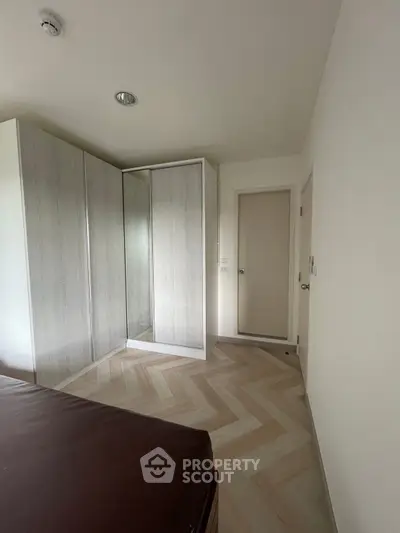 Modern bedroom with stylish wardrobe and herringbone flooring