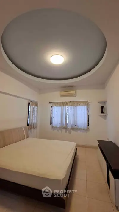 Spacious bedroom with modern ceiling design and natural light