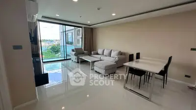 Spacious modern living room with large windows and elegant furniture in a high-rise apartment.