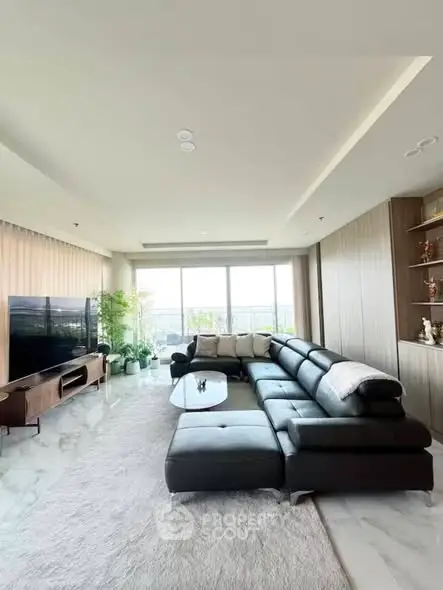 Spacious modern living room with large sectional sofa and panoramic window view.