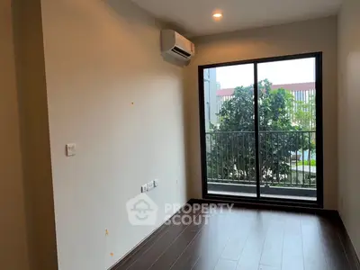 Modern room with large window and balcony view, featuring sleek flooring and air conditioning unit.