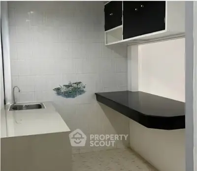 Compact kitchen with sleek black countertop and modern cabinetry