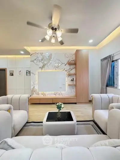Luxurious living room with elegant marble wall and plush seating, perfect for modern comfort and style.
