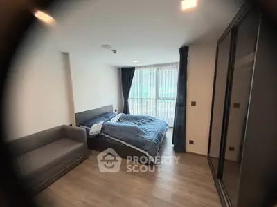 Modern bedroom with large window and stylish furnishings in a contemporary apartment.
