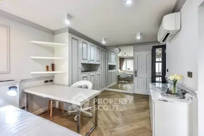 Spacious study room with modern decor and ample storage in a stylish apartment.