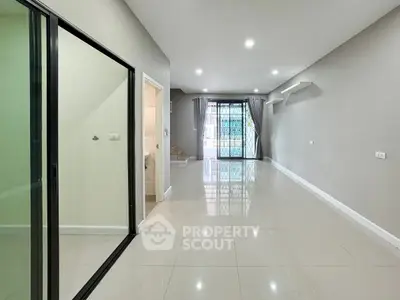 Spacious modern living room with glossy tiled floors and large windows for natural light.