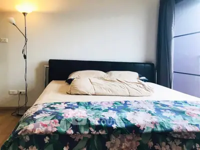 Cozy bedroom with stylish bed and floral bedding, perfect for relaxation and comfort.