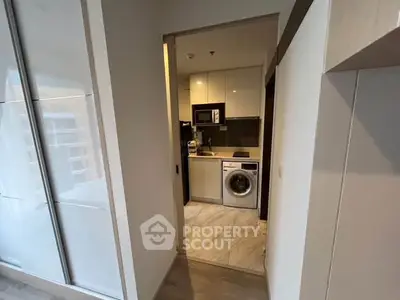 Modern compact kitchen with washing machine and sleek cabinetry