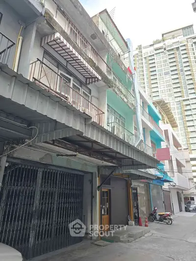 Explore this urban building exterior with multiple balconies and a modern high-rise backdrop.