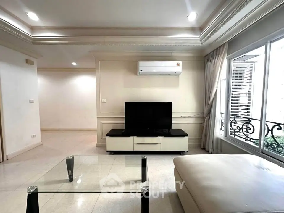 Spacious living room with modern air conditioning and elegant decor, featuring a large window for natural light.