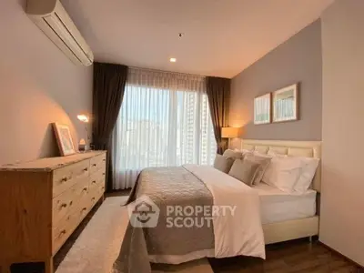 Elegant bedroom with city view, featuring a cozy bed, stylish decor, and ample natural light.