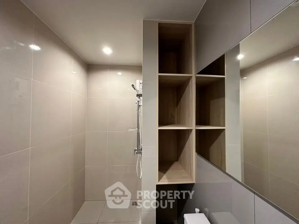 Modern bathroom with sleek shower and built-in shelving, perfect for contemporary living.