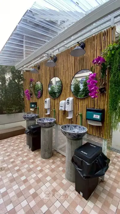 Stylish outdoor bathroom with elegant sinks and lush greenery
