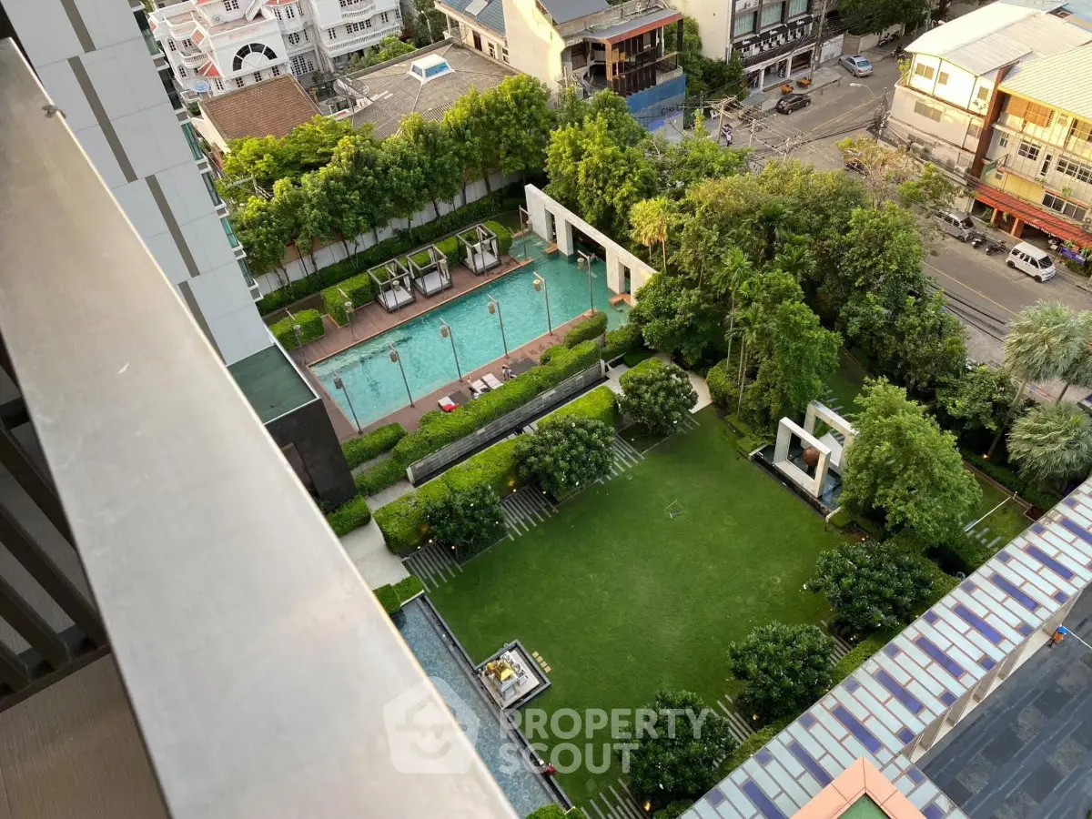 Stunning aerial view of modern apartment complex with lush garden and inviting swimming pool.