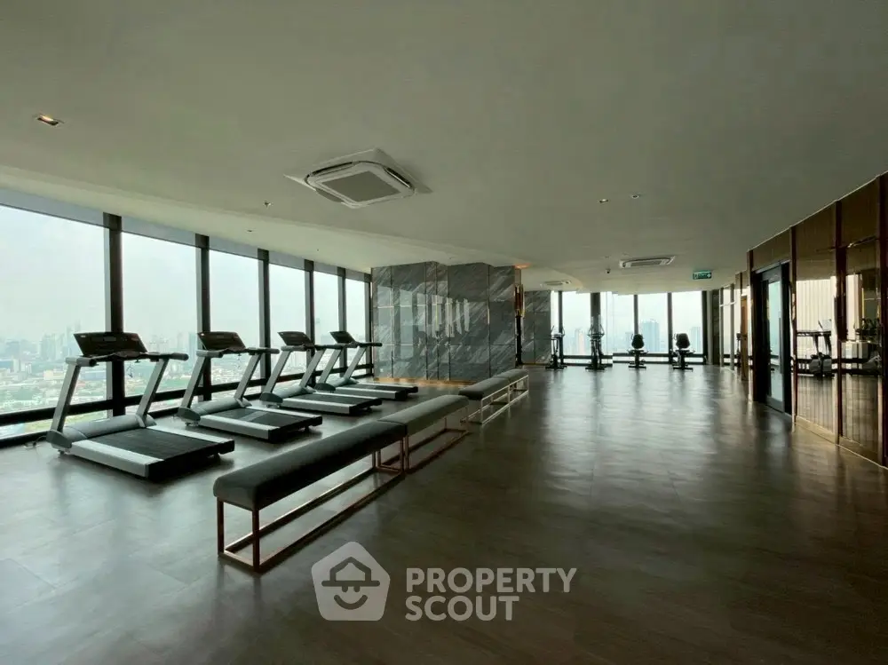 Luxurious high-rise gym with panoramic city views and modern fitness equipment.