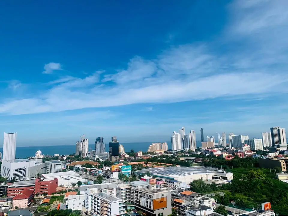 Stunning cityscape view with ocean backdrop and modern high-rise buildings under a clear blue sky.