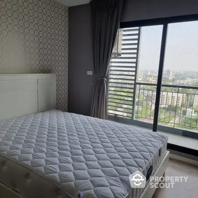 Spacious bedroom with a large window offering an expansive city view, featuring a stylish patterned accent wall and a comfortable bed awaiting new owners.