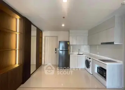 Modern kitchen with sleek appliances and ample storage in a stylish apartment.