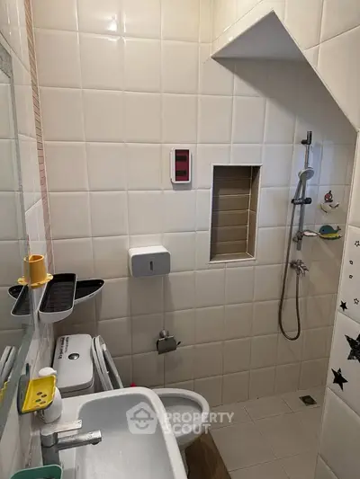 Compact bathroom with shower and modern fixtures in a cozy apartment.