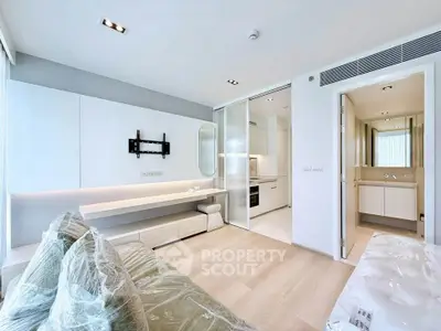 Modern apartment interior with open kitchen and living area, featuring sleek design and natural lighting.