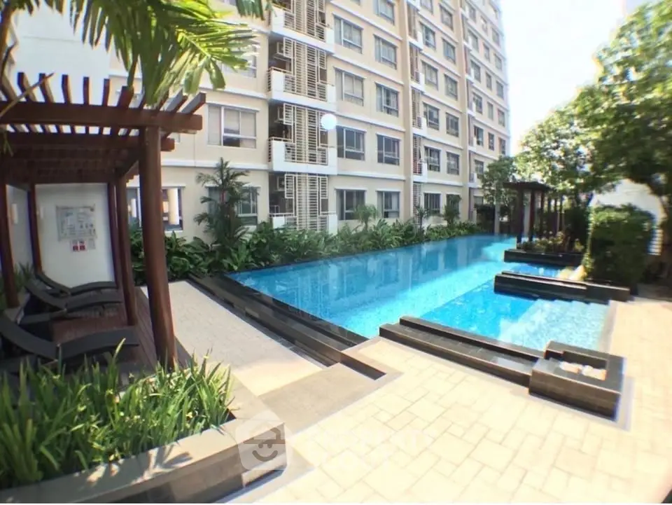 Luxurious apartment complex with stunning outdoor pool and lush greenery.