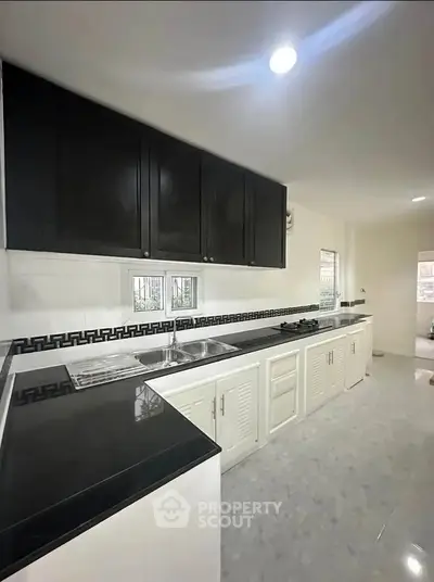 Modern kitchen with sleek black and white cabinetry and gas stove
