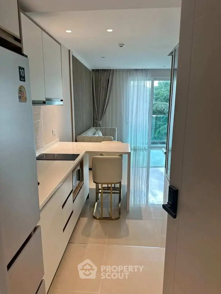 Modern kitchen with sleek design and open layout leading to a bright living area.