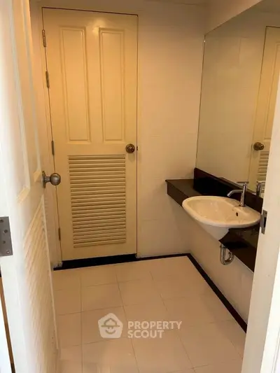 Modern bathroom with sleek sink and large mirror in a stylish real estate property.