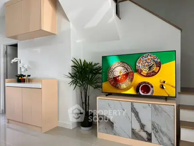 Modern living room with stylish TV stand and elegant decor under staircase
